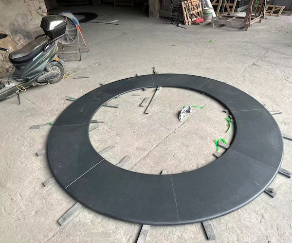 Circular Absolute Black Granite fabrication component on a factory floor during processing