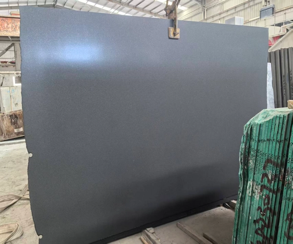 Dark black granite slab held upright in a supplied factory quality-control reference