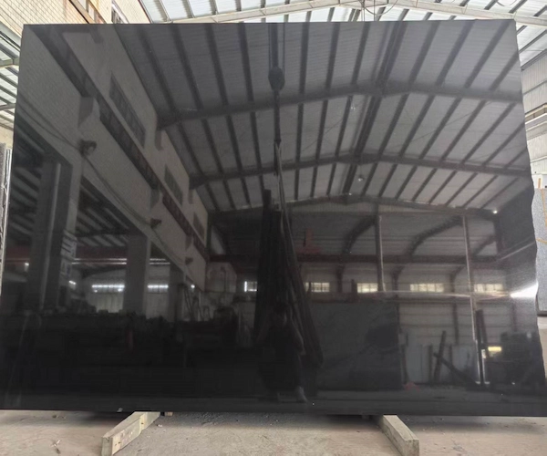 Polished Absolute Black Granite slab held vertically for supplied factory inspection