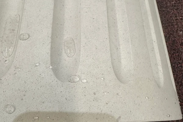 Beige Limestone fluted capital detail with carved grooves during quality review