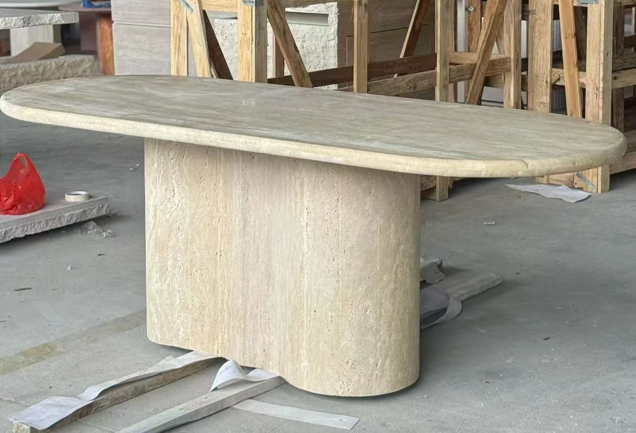 Rounded beige travertine dining table base shown during workshop production review