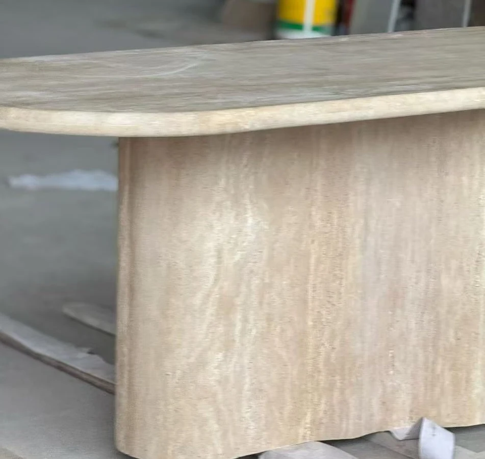 Oval travertine tabletop and rounded stone base shown during furniture assembly inspection