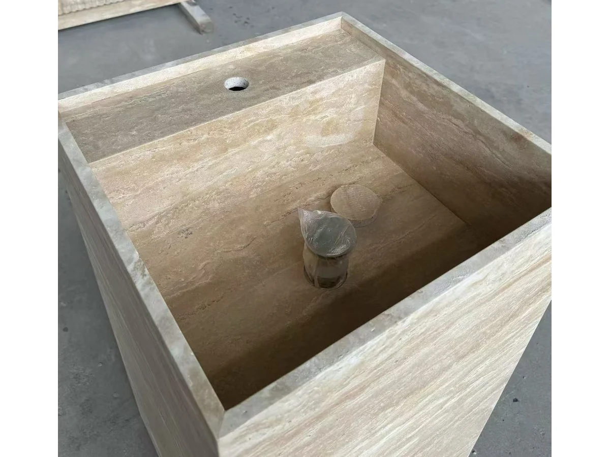 Travertine pedestal vanity faucet opening alignment inspected during quality review