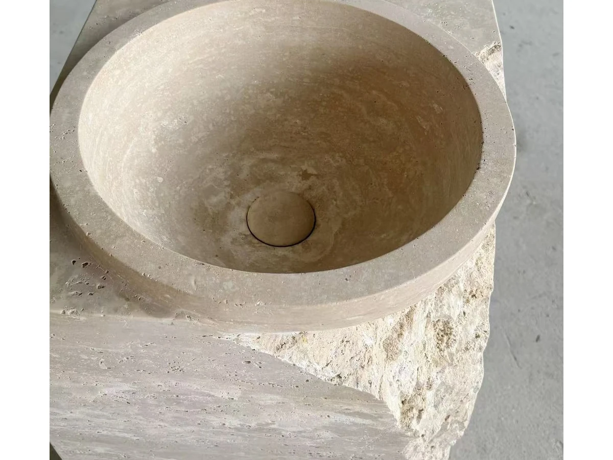Travertine vanity drain opening and stone surface inspected before final workshop release