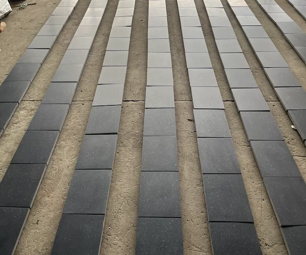 Honed G684 Black Basalt paving tiles arranged for factory dry-lay review