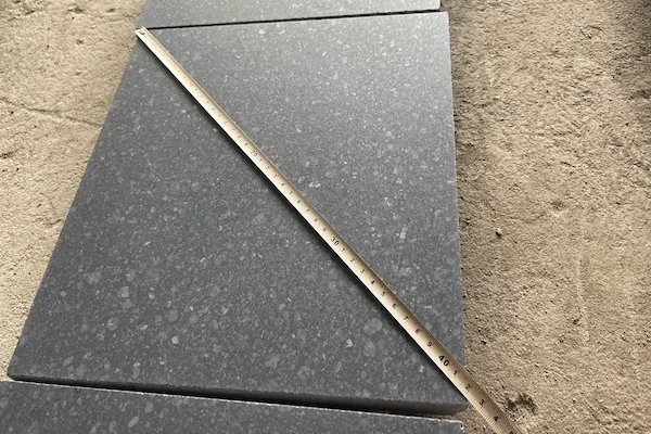 Honed G684 Black Basalt tiles with a measuring rule in a supplied dimensional-check image