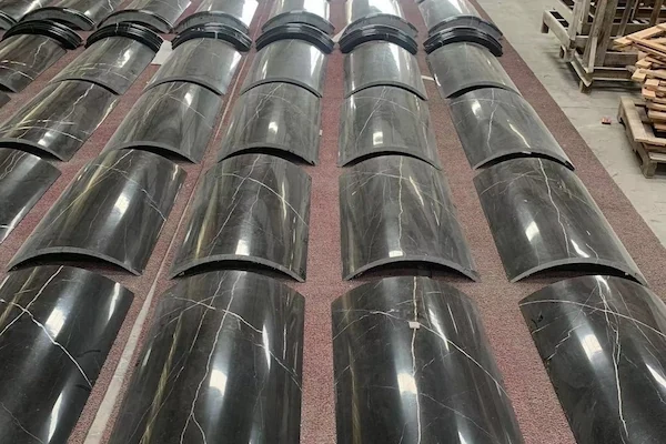 Black Marble curved column-cladding segments grouped for workshop joint review