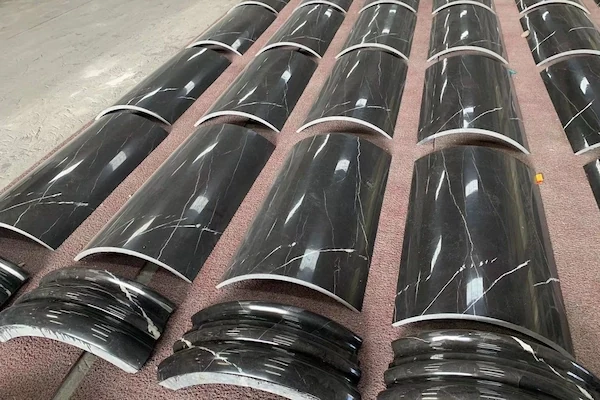 Polished Black Marble curved column components arranged in parallel for quality review