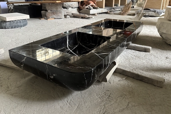 Supplied factory reference of a black marble vanity top during edge-cutting inspection