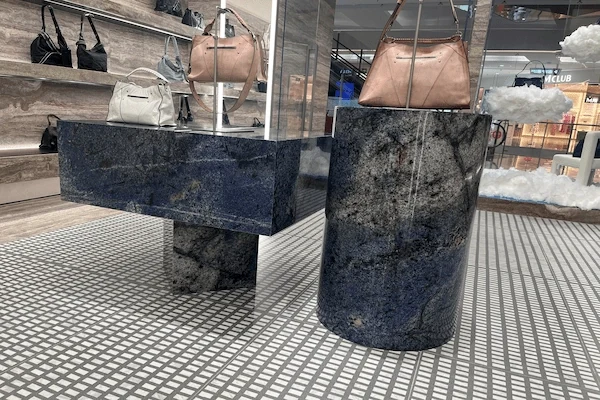 Blue sodalite quartzite reception desk with a curved stone support and display counter detail