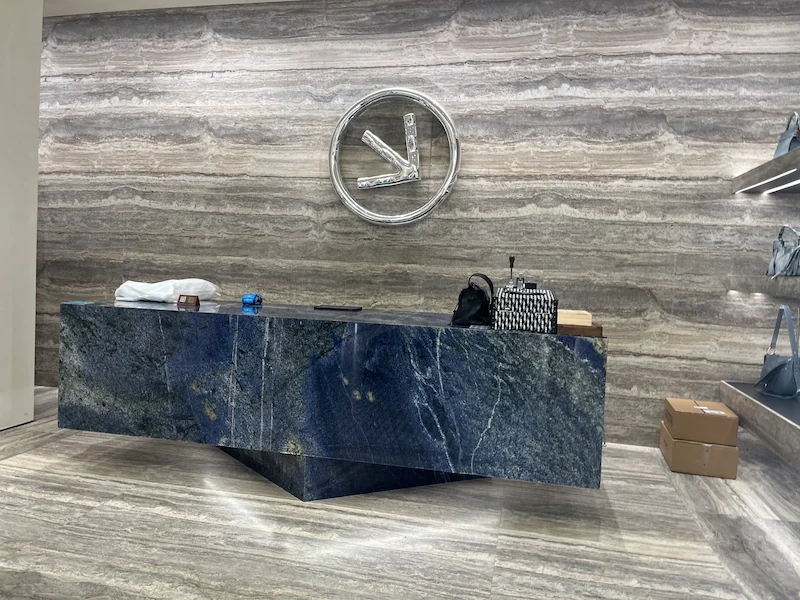 Blue sodalite quartzite reception desk with deep blue veining and a stepped front profile in a display setting