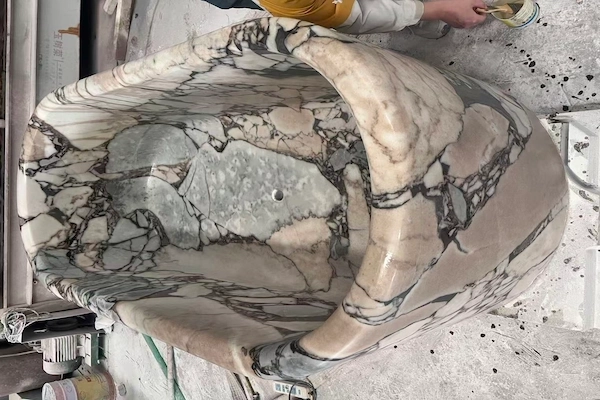 Supplied workshop reference of a Calacatta Viola marble bathtub during surface-finishing work