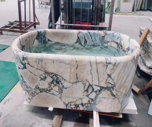 Supplied workshop reference of a Calacatta Viola marble bathtub filled with water during an observed quality-control step