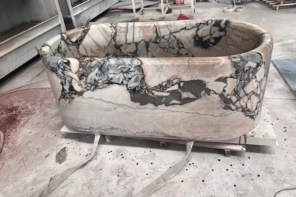 Supplied workshop reference of a Calacatta Viola marble oval bathtub body on a fabrication floor