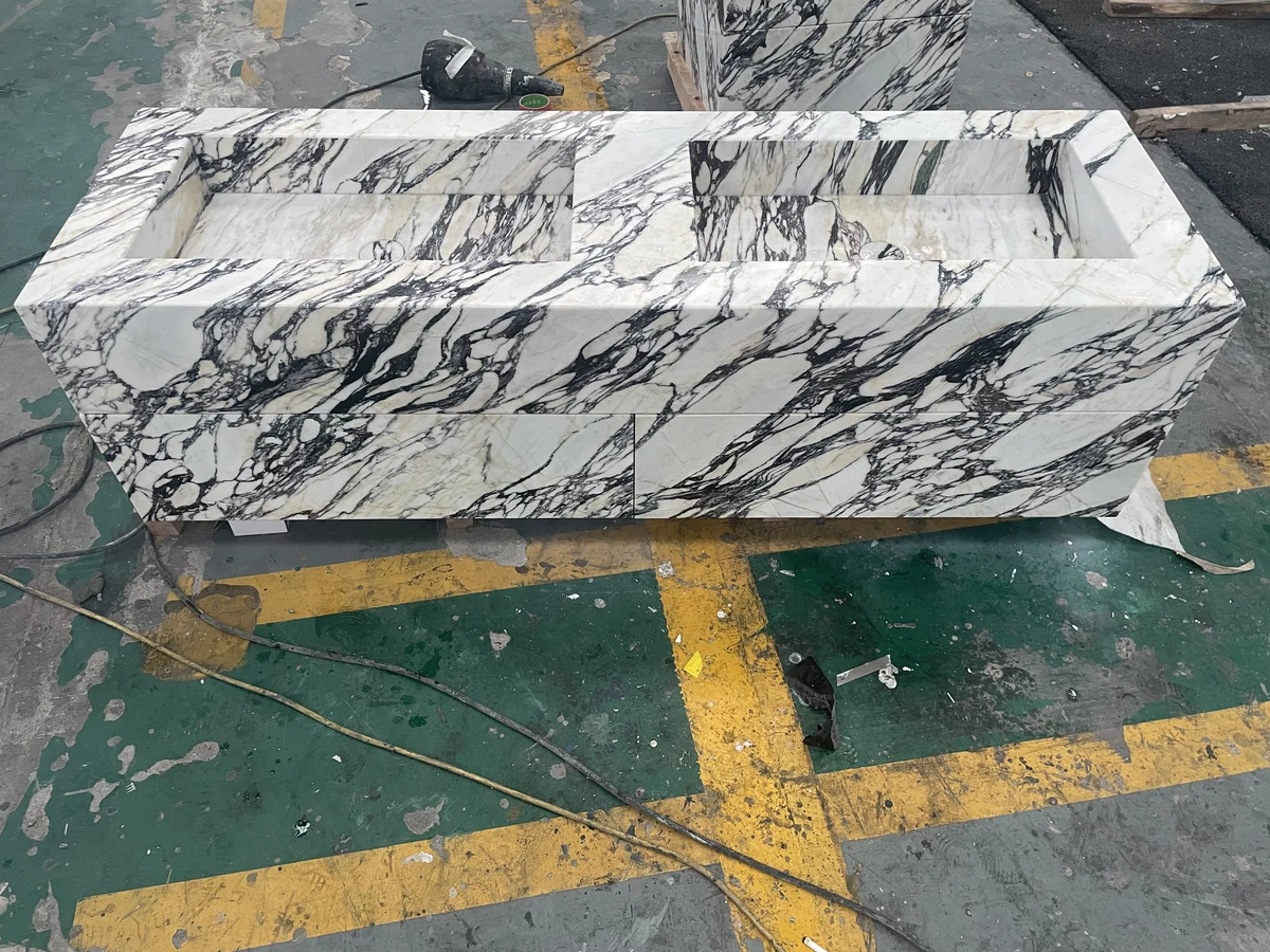 Calacatta Viola marble panels arranged for vein-matching review during double vanity fabrication