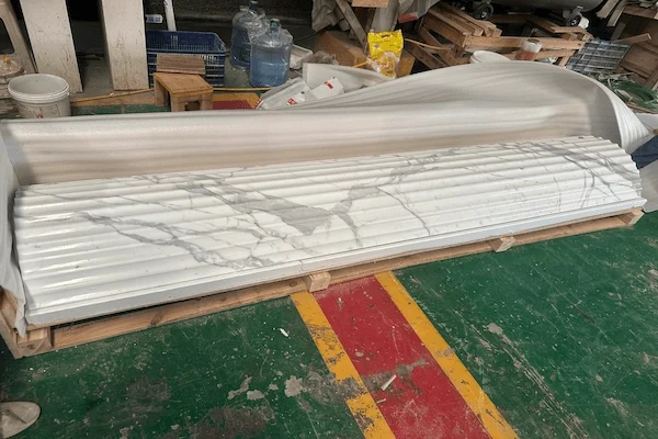 Long Calacatta White Marble fluted column components arranged for workshop profile inspection