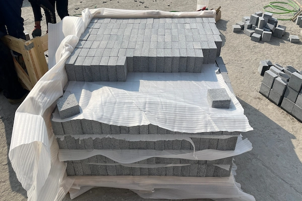 Classic Grey Granite cube stones arranged in a wooden crate with protective sheets between packed layers