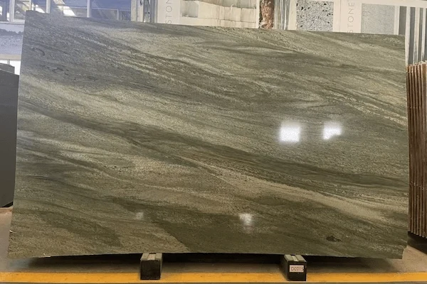 Green Granite slabs displayed in a warehouse review area with polished directional movement