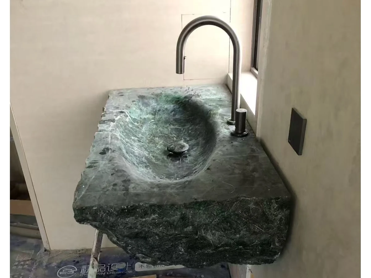 Wall-mounted green marble vanity drain and faucet openings reviewed during fabrication checks