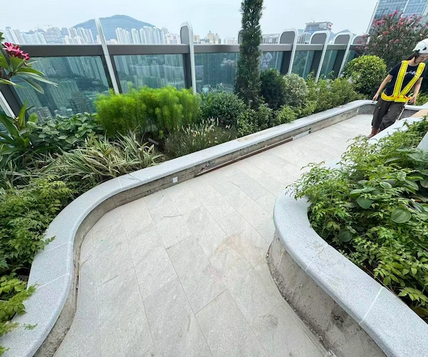 Flamed Grey Granite curved coping installed along an outdoor landscaped walkway