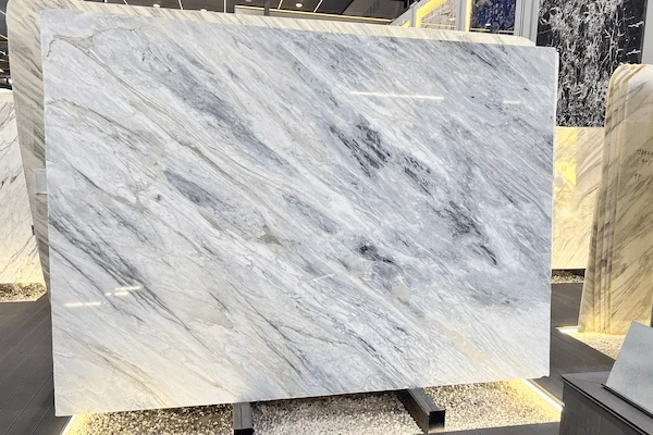 Manhattan Marble slab in a display review setting with white-grey field and dark linear veining