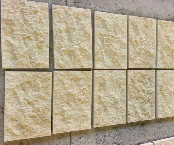 Supplied reference of beige Rock Face Limestone cladding pieces aligned on a work surface for visual review