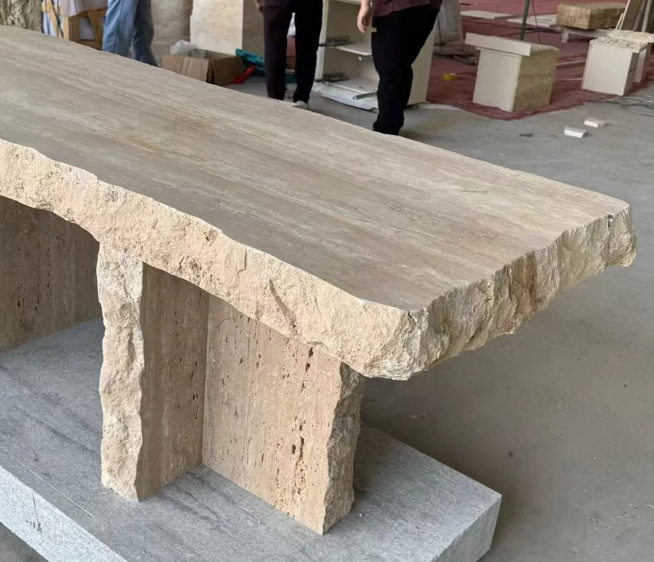 Textured travertine coffee table edge and block support shown during production inspection