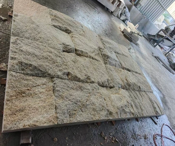 Rusty Yellow Granite natural-split stone panels arranged for visual dry-lay review on a supplied factory floor