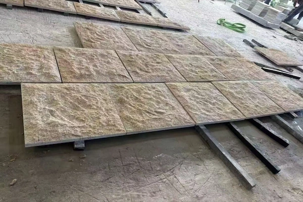 Rusty Yellow Granite natural-split tiles set out for quality acceptance in a supplied factory work area