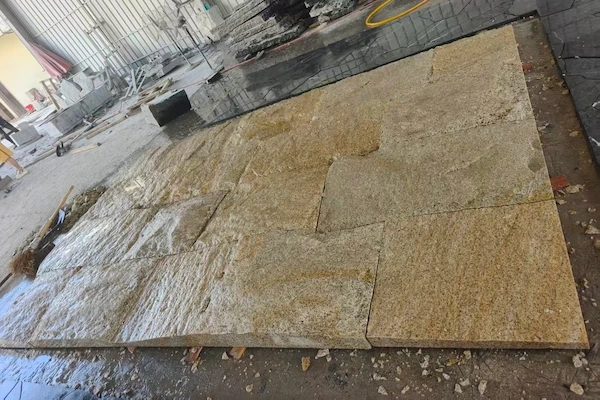 Rusty Yellow Granite natural-split cladding panels in a supplied factory dimension-check layout