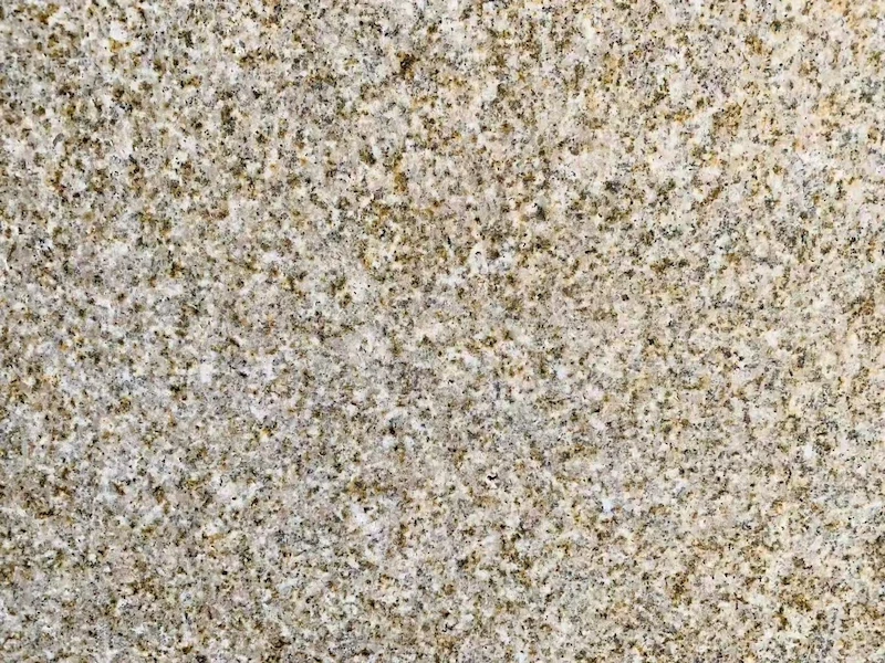 Rusty Yellow Granite natural-split surface with warm yellow, beige and muted grey mineral variation in a supplied material reference