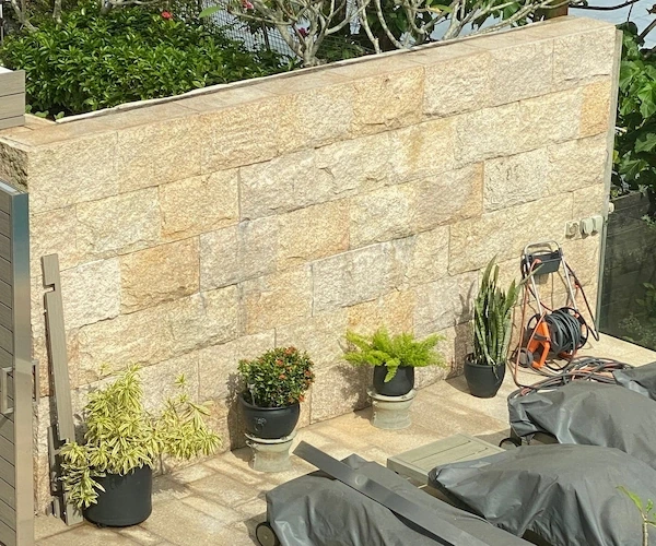 Rusty Yellow Granite natural-split retaining wall shown in a supplied finished wall reference
