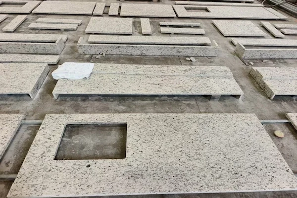 Santa Cecilia White Granite island top pieces shown in a supplied workshop review image
