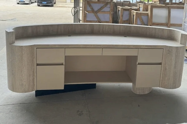 Semi-circular beige travertine reception desk with integrated cabinets shown during workshop review