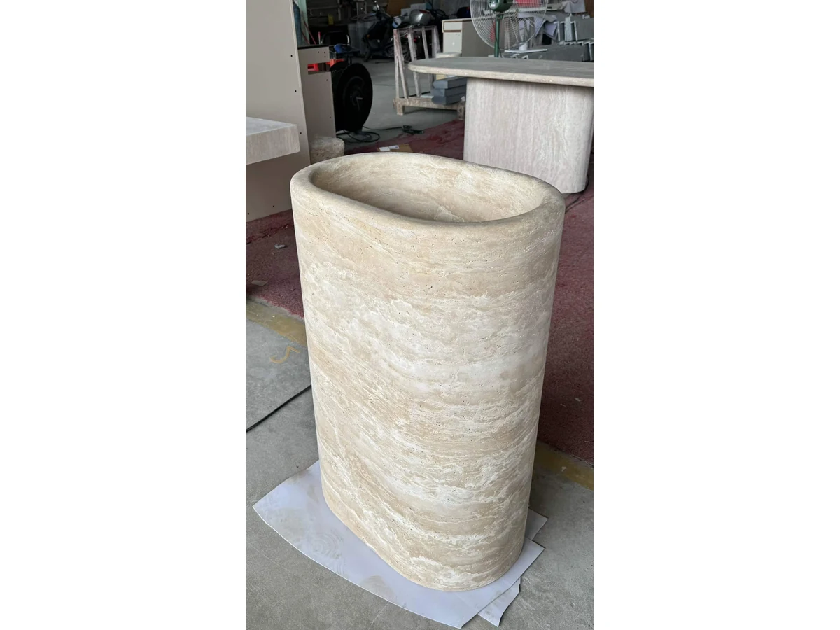 Round travertine pedestal vanity basin detail inspected during workshop fabrication