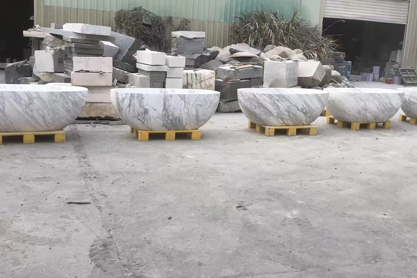 Supplied workshop-yard reference showing a lineup of Volakas White marble oval freestanding bathtubs