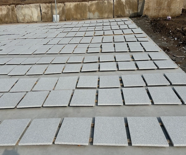 White Granite flooring tiles arranged for dry-lay review in a supplied factory setting