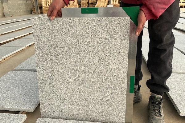 White Granite cut-to-size tile held for angle and squareness review in a supplied factory quality-check image