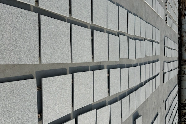 Honed White Granite tiles set out for dry-lay acceptance in a supplied factory layout reference