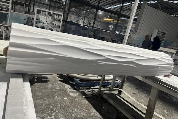 Long White Marble fluted column shaft component supported for workshop inspection