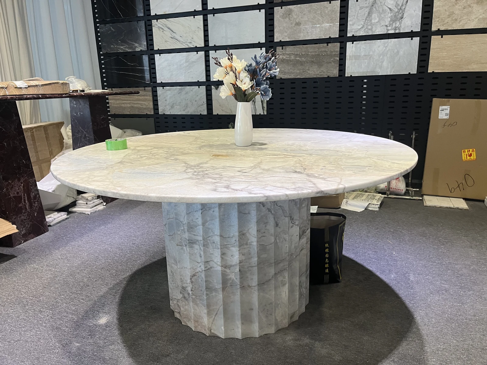 Round white marble coffee table top and fluted pedestal base shown during workshop assembly